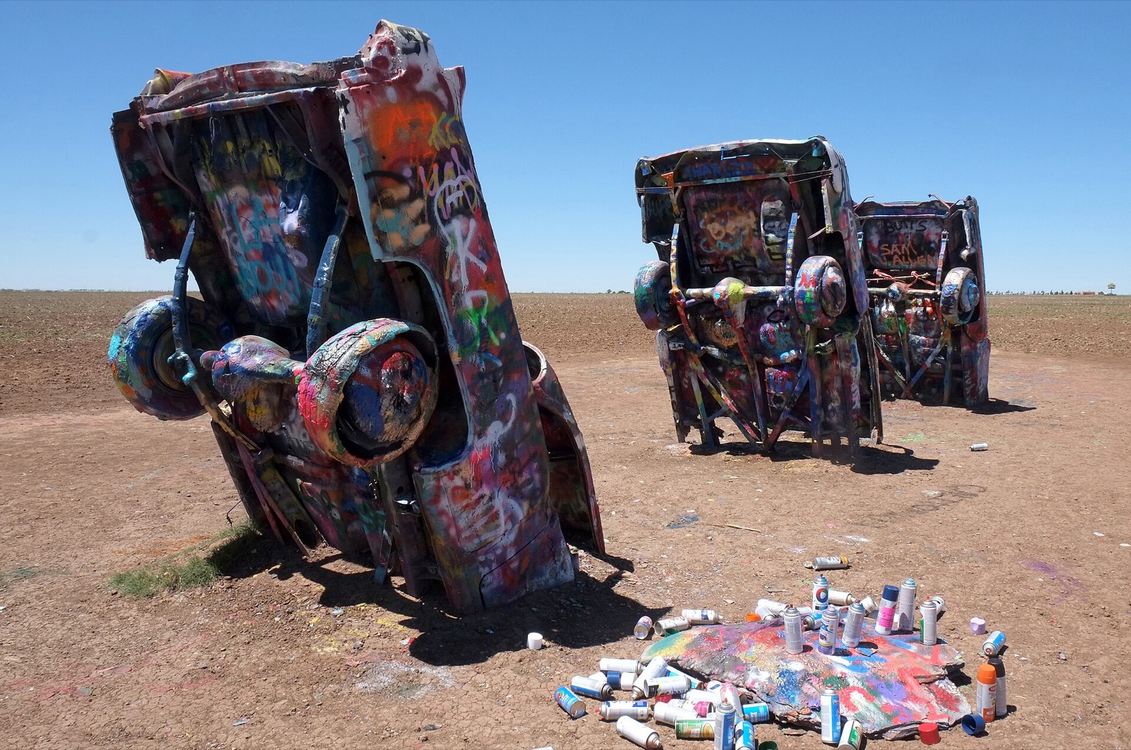 Spray-painted Cadillacs and empty paint cans at Cadillac Ranch